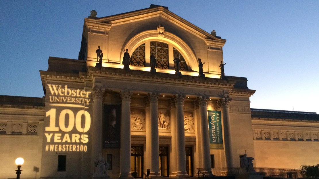 The Saint Louis Art Museum illuminated at night with "̳ 100 Years" shining on the building.